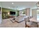 Stylish living room with a large sofa, media console, and sliding glass doors to the outdoor space at 20472 Monza Loop, Land O Lakes, FL 34638