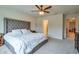 Serene main bedroom with a tufted headboard, soft lighting, and access to the ensuite bathroom at 20472 Monza Loop, Land O Lakes, FL 34638