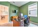 Bright office features an executive desk and large window, creating a functional and inviting workspace at 20472 Monza Loop, Land O Lakes, FL 34638