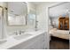 Bright bathroom featuring a white vanity with ship lap, modern fixtures, and a view into the bedroom at 2057 Kansas Ne Ave, St Petersburg, FL 33703