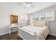 Comfortable bedroom featuring a white bed, hardwood floors, and natural light from the shuttered windows at 2057 Kansas Ne Ave, St Petersburg, FL 33703