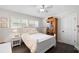 Charming bedroom featuring hardwood floors, a ceiling fan, and bright natural light from the shuttered windows at 2057 Kansas Ne Ave, St Petersburg, FL 33703