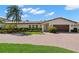 Charming one-story home featuring a red tile roof, manicured landscaping, and a brick driveway at 2057 Kansas Ne Ave, St Petersburg, FL 33703