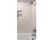 Close-up of the shower featuring sleek, elongated tiles, built-in shelving, and modern shower fixtures at 2057 Kansas Ne Ave, St Petersburg, FL 33703