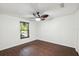 This spacious bedroom has a modern ceiling fan, wood-look floors, a closet with white doors and a window at 2141 Brent Pl, Palm Harbor, FL 34683