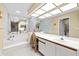 Bathroom boasts a spa tub with step-up access, vanity with a seat and a large mirror at 235 Woodridge Cir, Oldsmar, FL 34677