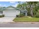 Charming single Gathering home with a well-manicured lawn and attached garage at 235 Woodridge Cir, Oldsmar, FL 34677