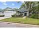 Charming home with a well-manicured lawn, mature landscaping, and an attached garage at 235 Woodridge Cir, Oldsmar, FL 34677