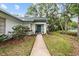 Inviting front entrance with a well-maintained walkway and lush landscaping at 235 Woodridge Cir, Oldsmar, FL 34677
