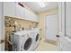 Functional laundry room featuring a washer, dryer, cabinets, sink, and a well-lit interior perfect for managing household chores at 235 Woodridge Cir, Oldsmar, FL 34677