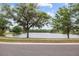 Scenic view of community pond surrounded by lush greenery, trees, and landscaping at 235 Woodridge Cir, Oldsmar, FL 34677