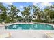 Community pool featuring a covered seating area, lounge chairs, and ladder entry and exit at 235 Woodridge Cir, Oldsmar, FL 34677