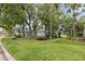 Well-maintained front yard showcasing mature trees, landscaping, and a lush green lawn at 235 Woodridge Cir, Oldsmar, FL 34677