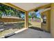 Covered back porch overlooking a spacious backyard with a wooden fence and mature trees at 24231 Satinwood Ct, Lutz, FL 33559