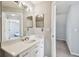 Bathroom with white vanity, large mirror, and adjacent hallway and bedroom access at 24231 Satinwood Ct, Lutz, FL 33559