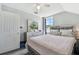 Bright bedroom with a large window, mirrored dresser, and plush bed with decorative pillows at 24231 Satinwood Ct, Lutz, FL 33559