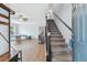 Bright entryway with stairs and open view to living area with a dining table and piano at 24231 Satinwood Ct, Lutz, FL 33559
