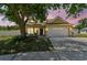 Charming home with a two-car garage and a well-maintained front yard shaded by a mature tree at 24231 Satinwood Ct, Lutz, FL 33559