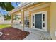 Inviting front porch with rocking chairs, a modern front door, and manicured landscaping at 24231 Satinwood Ct, Lutz, FL 33559