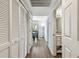 Hallway leading to a dining area and bathroom, showcasing white closets and doors at 24231 Satinwood Ct, Lutz, FL 33559