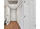Hallway with white doors, closets, and vinyl plank flooring leading to a bathroom at 24231 Satinwood Ct, Lutz, FL 33559