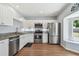 Well-lit kitchen with stainless steel appliances, white cabinets, and modern countertops at 24231 Satinwood Ct, Lutz, FL 33559
