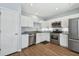 Modern kitchen with stainless steel appliances, white cabinetry, and granite countertops at 24231 Satinwood Ct, Lutz, FL 33559