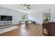 Spacious living room with wood floors, ceiling fan, natural light, and an adjacent piano at 24231 Satinwood Ct, Lutz, FL 33559