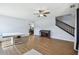 Bright living room featuring wood floors, neutral walls, a piano, and staircase access at 24231 Satinwood Ct, Lutz, FL 33559