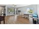 Open-concept living room with wood floors, large windows, and built-in dining benches at 24231 Satinwood Ct, Lutz, FL 33559