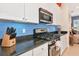Stylish kitchen featuring stainless steel appliances, granite countertops and blue tile backsplash at 2875 Grazeland Dr, Sarasota, FL 34240