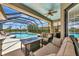 Covered outdoor space with seating near screened-in pool with water view at 2875 Grazeland Dr, Sarasota, FL 34240