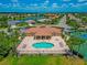Aerial view of pool and clubhouse with tennis courts and scenic neighborhood in the background at 2875 Grazeland Dr, Sarasota, FL 34240