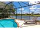 A lounge chair sits by a screened-in pool with views of the water at 2875 Grazeland Dr, Sarasota, FL 34240