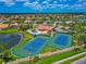 Aerial view of tennis courts with pool, clubhouse and scenic neighborhood in the background at 2875 Grazeland Dr, Sarasota, FL 34240
