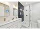 Bright bathroom featuring a glass shower, dual sinks, quartz countertop and gold hardware at 3106 W Cherokee Ave, Tampa, FL 33611