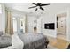 Bedroom featuring hardwood floors, a ceiling fan, french doors, and a walk-in bathroom at 3106 W Cherokee Ave, Tampa, FL 33611