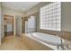 Large bathroom with soaking tub, glass block window, and walk-in closet at 3510 Hickory Hammock Loop, Wesley Chapel, FL 33544
