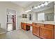 Bathroom with dual sinks and views into living space and glass block window at 3510 Hickory Hammock Loop, Wesley Chapel, FL 33544