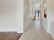 Bright hallway featuring tile flooring and archways, leading to a living area with wood floors at 3510 Hickory Hammock Loop, Wesley Chapel, FL 33544