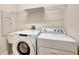 Laundry area with white washer and dryer and a utility sink with wire shelving at 3510 Hickory Hammock Loop, Wesley Chapel, FL 33544