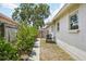 A backyard view of a white house with a gray brick path and green bushes at 511 Glenoak N St, St Petersburg, FL 33703