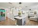 Open kitchen featuring an island with seating, stainless appliances, and wood flooring, leading to the living area at 511 Glenoak N St, St Petersburg, FL 33703