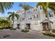 Attractive townhome exterior featuring stylish gray siding, white trim, and lush palm tree landscaping at 5912 Anchorage S Way, St Petersburg, FL 33712