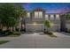 Twilight view of the townhouse with an attached two-car garage and well-maintained landscaping at 5922 Grand Sonata Ave, Lutz, FL 33558