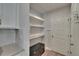 Mud room featuring built-in shelving, storage, and a coat rack, offering convenient organization at 5922 Grand Sonata Ave, Lutz, FL 33558