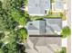 An overhead shot showcasing the property's roof, landscaping, and surrounding neighborhood with mature trees at 6015 Shell Ridge Dr, Lithia, FL 33547