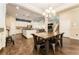 Spacious dining area open to kitchen and living room, featuring wood floors and stylish chandelier and stairway at 6015 Shell Ridge Dr, Lithia, FL 33547