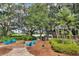 Beautiful outdoor fire pit area with Adirondack chairs and lush landscaping with lake views at 6015 Shell Ridge Dr, Lithia, FL 33547