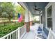 Relaxing front porch featuring white rocking chairs, a patriotic American flag, and a ceiling fan at 6015 Shell Ridge Dr, Lithia, FL 33547
